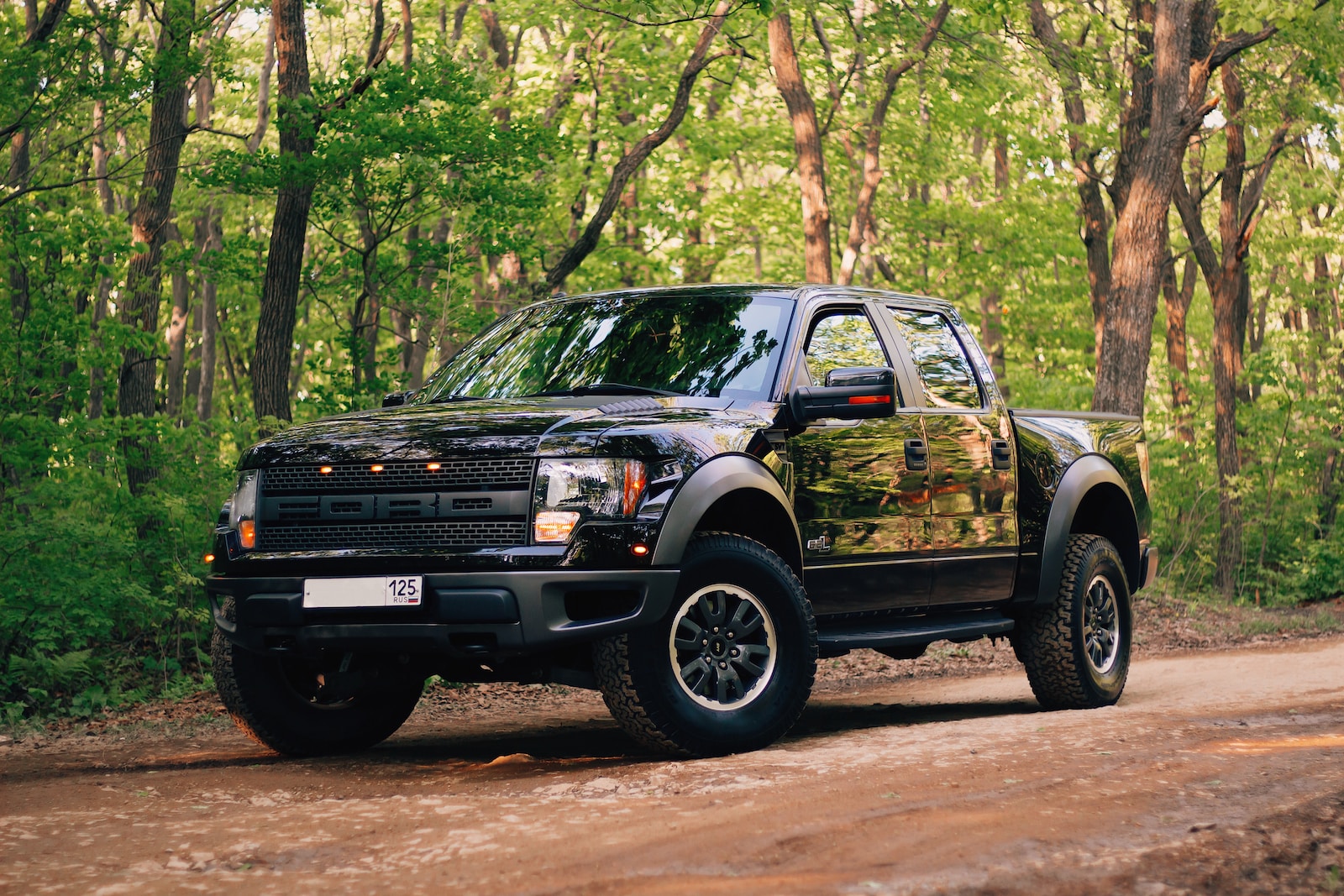 black and yellow chevrolet crew cab pickup truck parked on dirt road during daytime