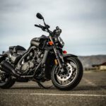 black and silver cruiser motorcycle on gray asphalt road during daytime