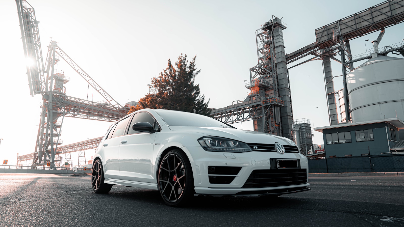 a white car parked in front of a factory