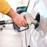 a man pumping gas into his car at a gas station