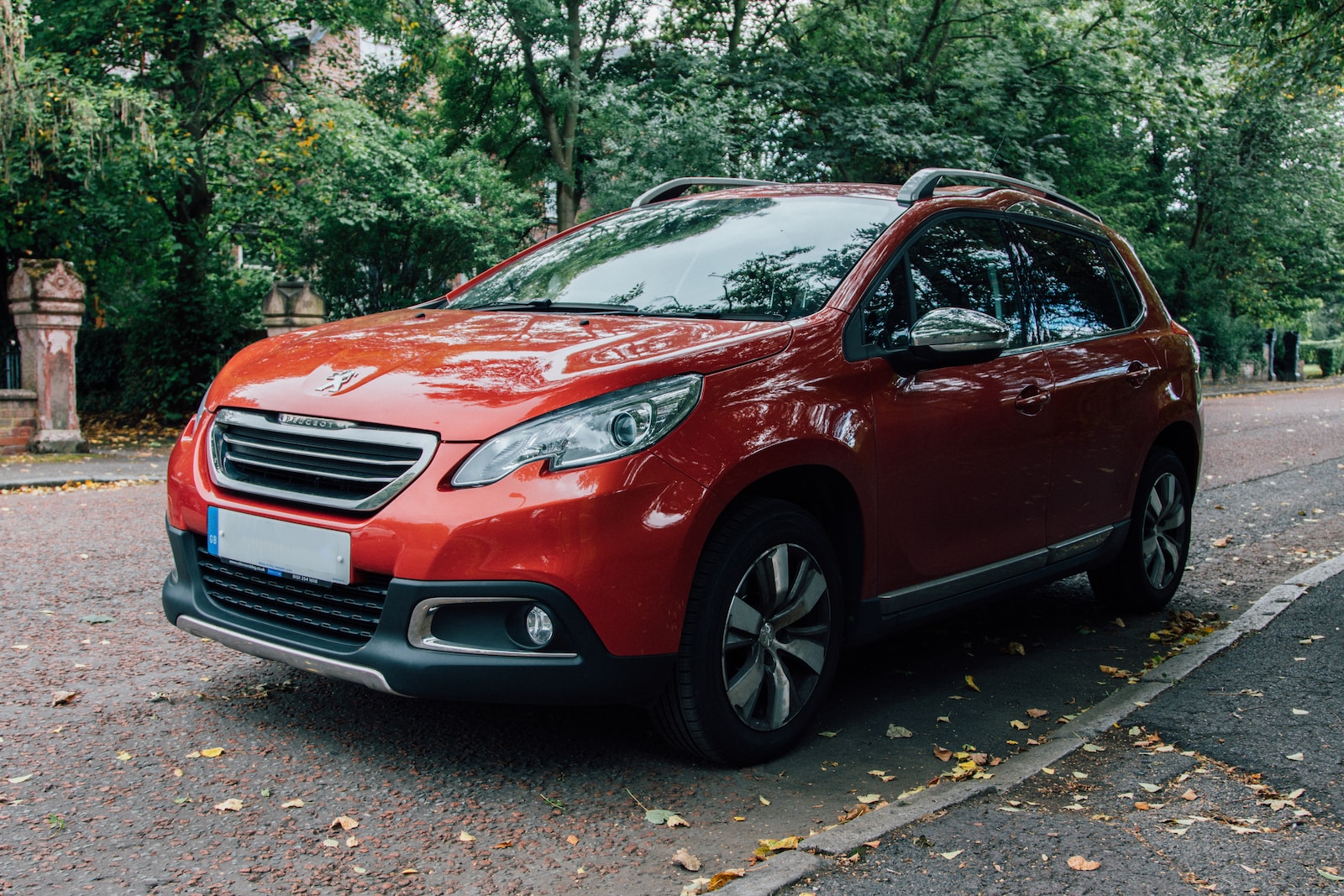 red Peugeot SUV parked beside curb