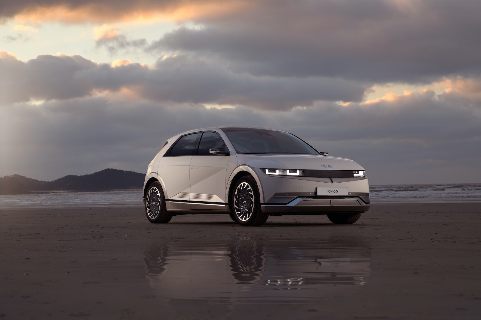 a white car parked on top of a sandy beach