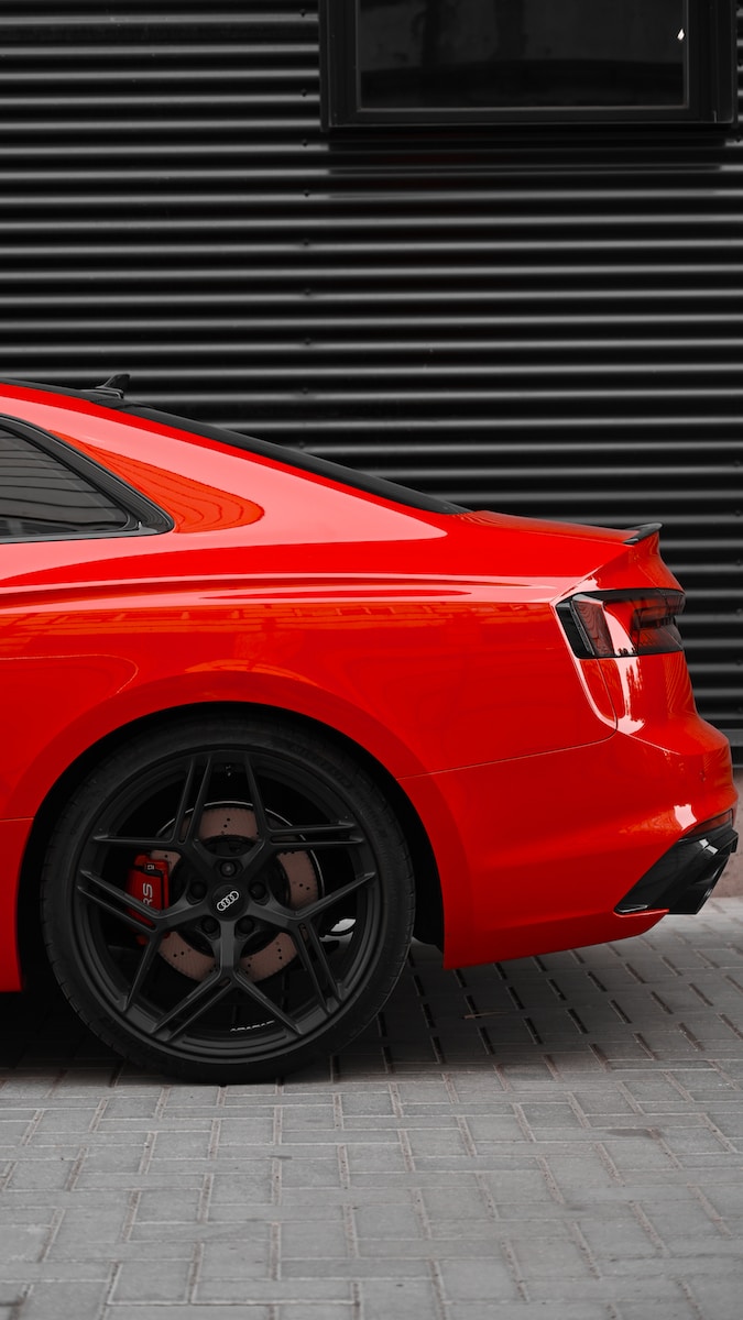 a red sports car parked in front of a garage door