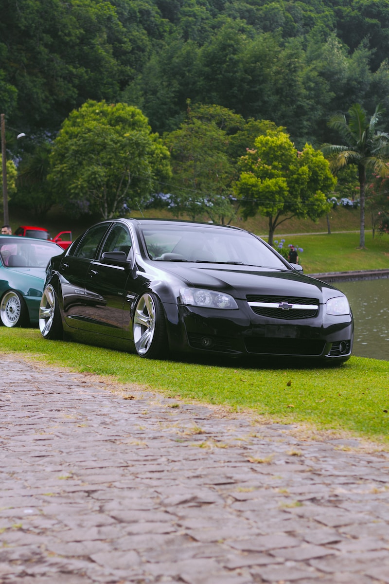 two cars parked next to each other near a body of water