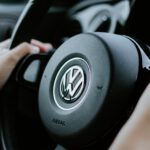 person holding black Volkswagen steering wheel in closed-up photo