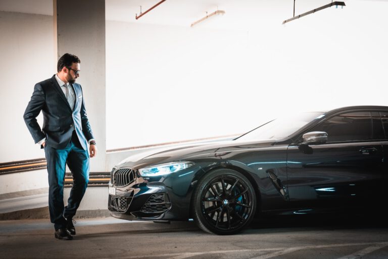 a man in a suit standing next to a car