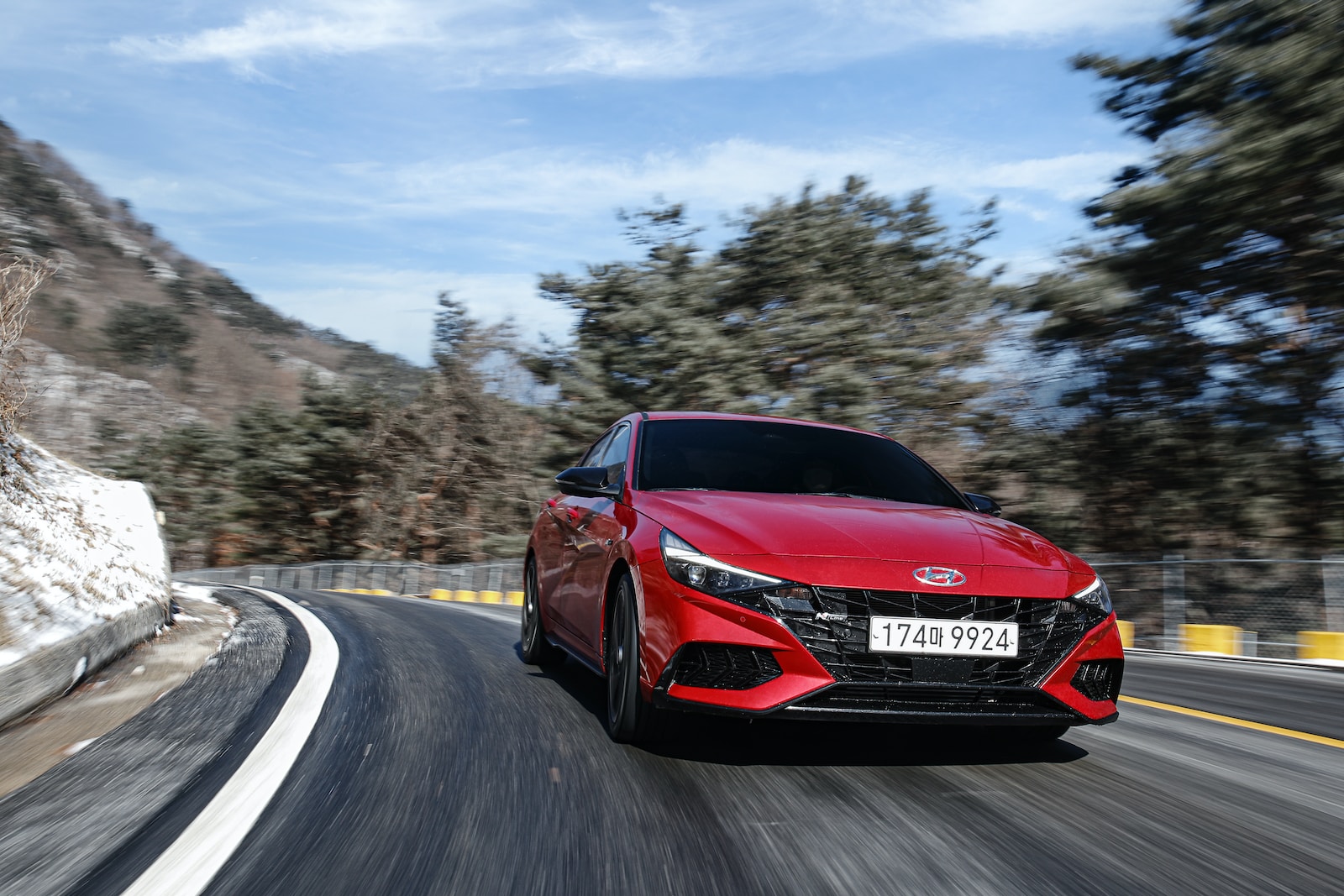 a red sports car driving down a road