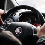 person riding FIAT car during daytime