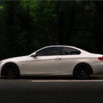 white coupe on black asphalt road