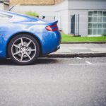 blue coupe parked in front of house