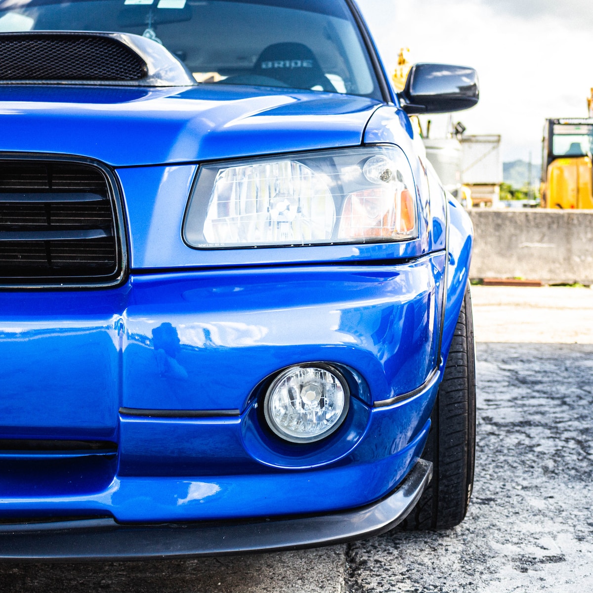 blue car parked on gray concrete road during daytime