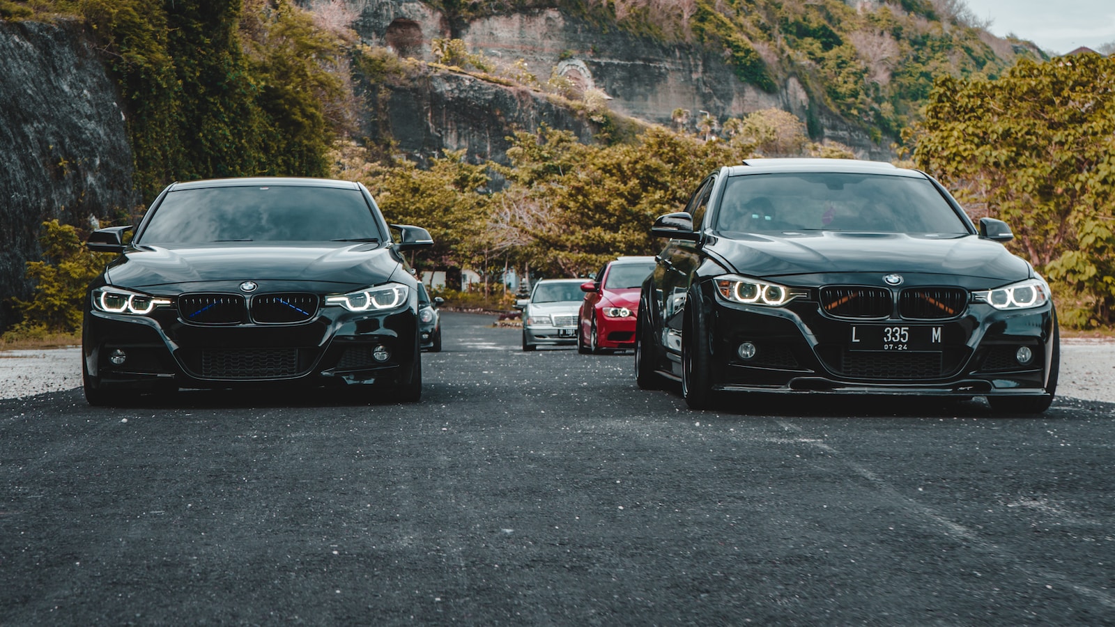 two black cars parked next to each other in a parking lot