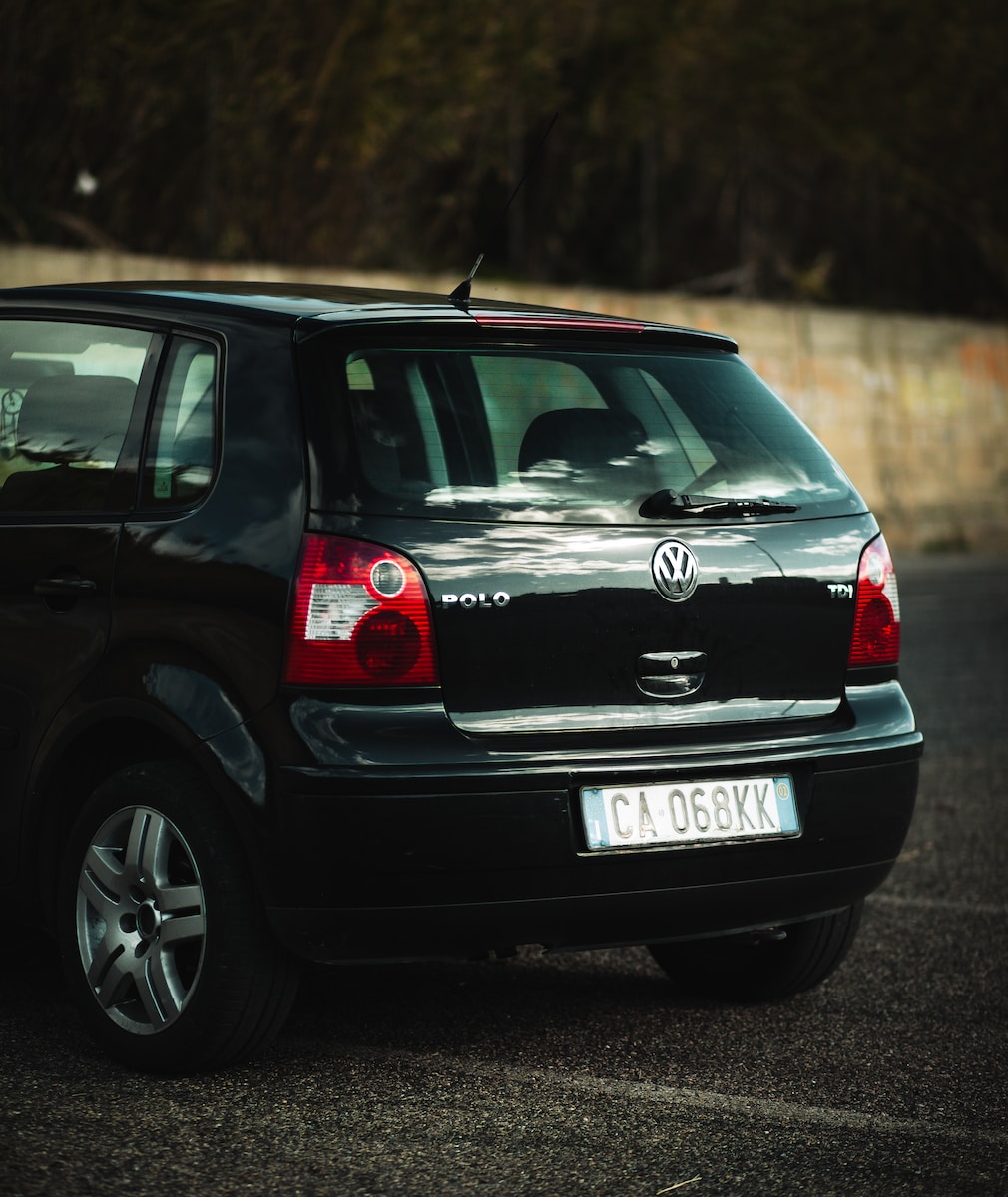 a small black car parked in a parking lot