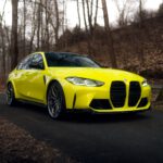 a yellow sports car driving down a road