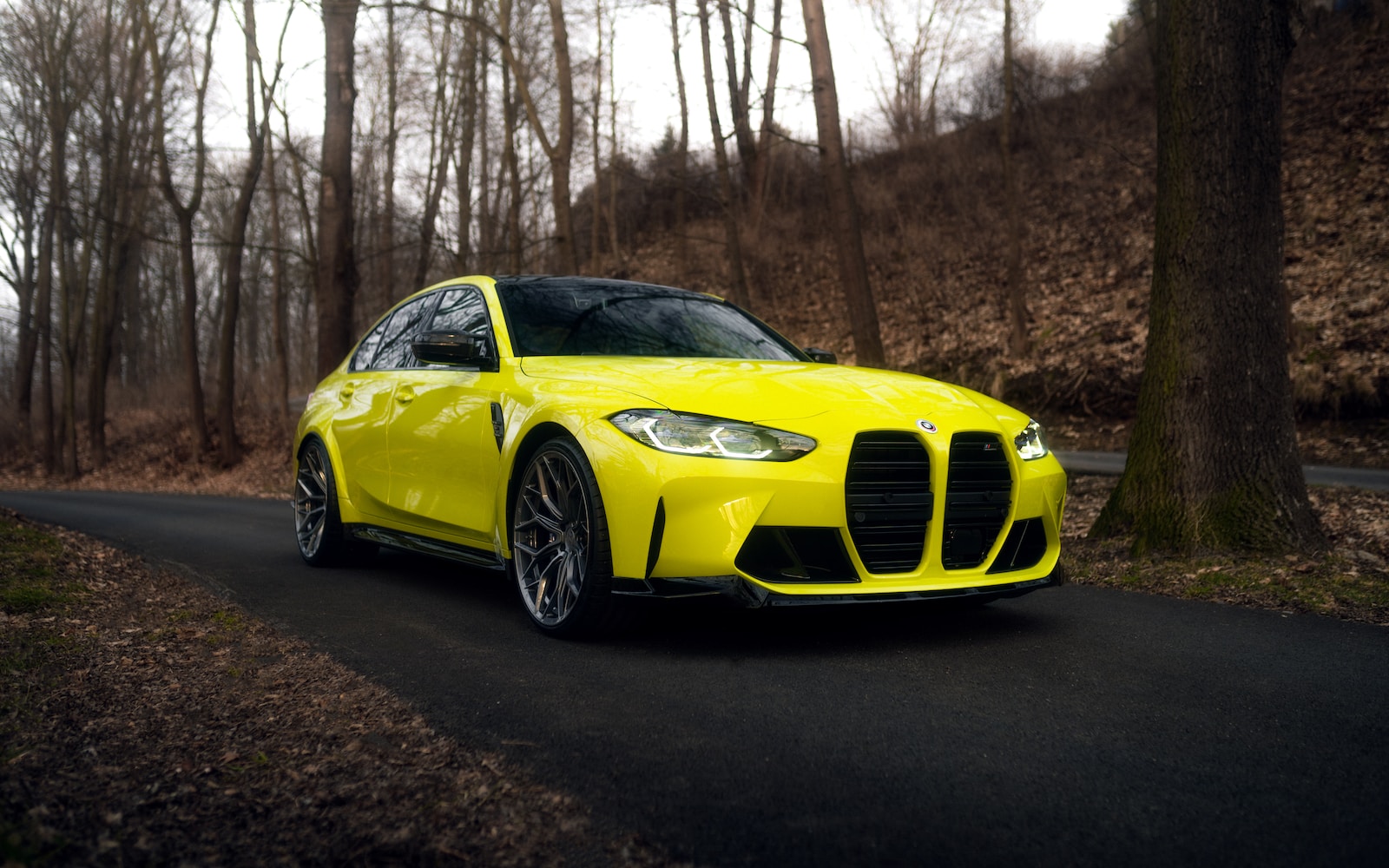 a yellow sports car driving down a road