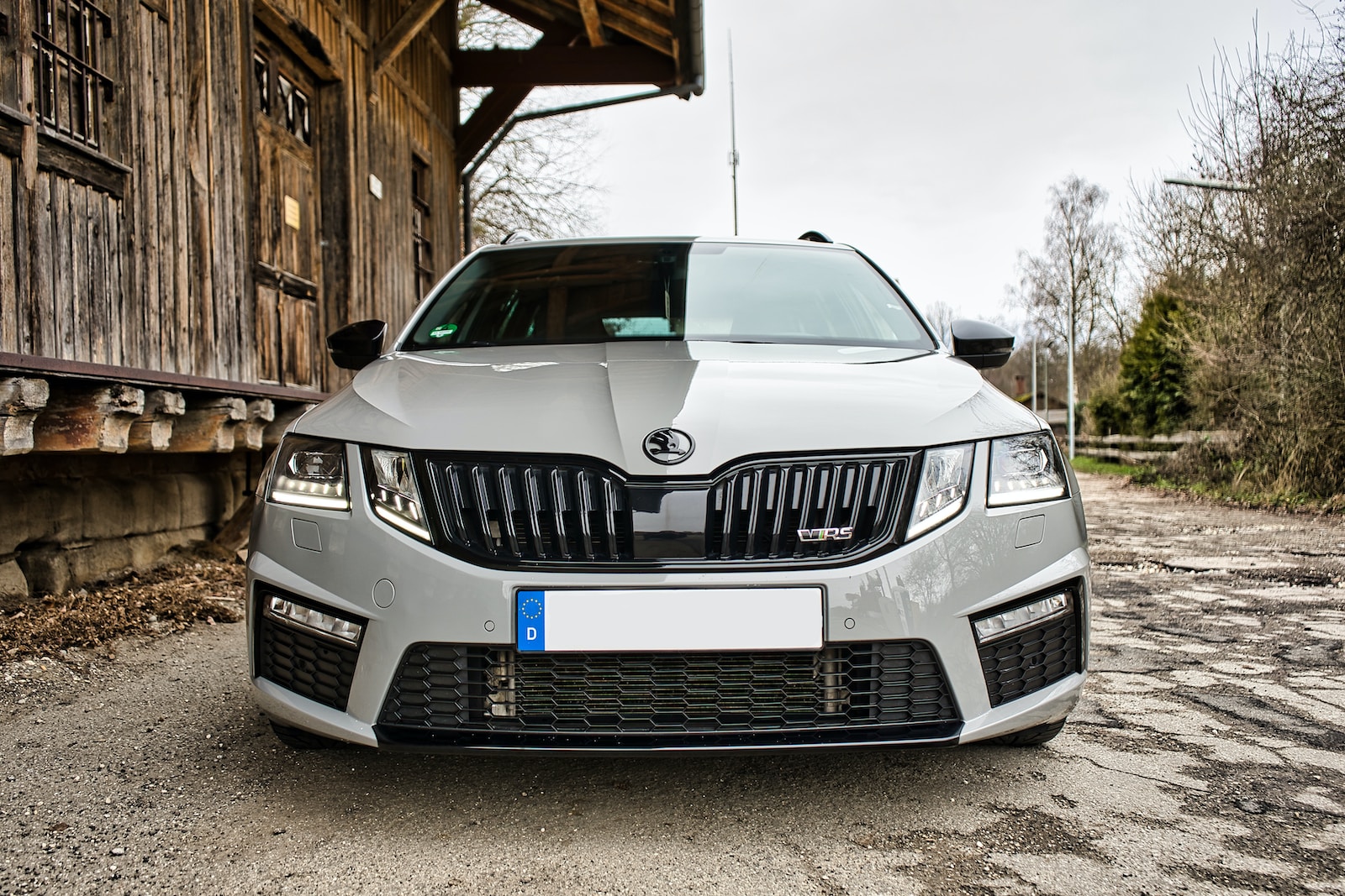 a silver car parked in front of a wooden building