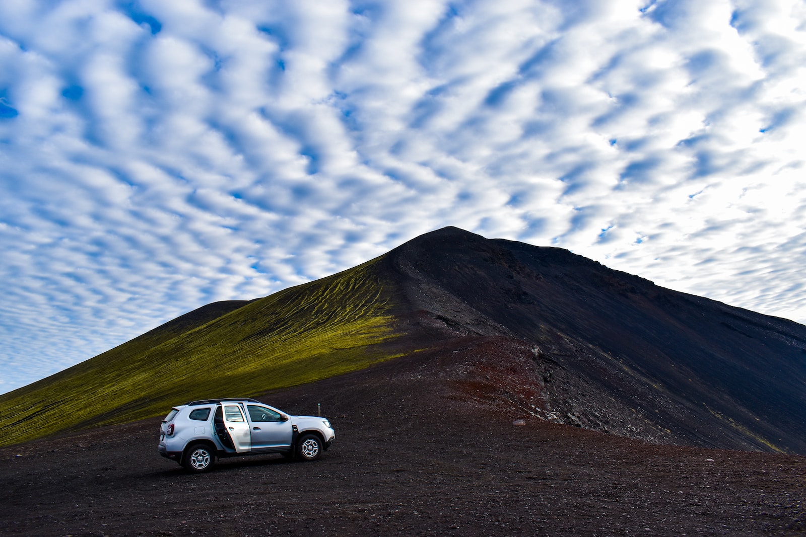 a white truck is parked in front of a mountain