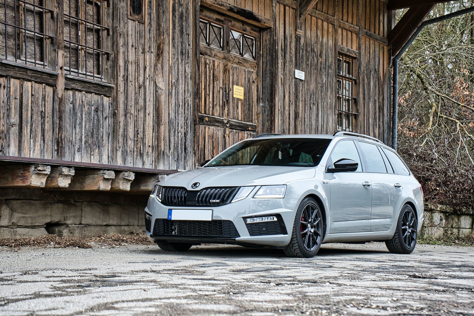 a white car parked in front of a wooden building