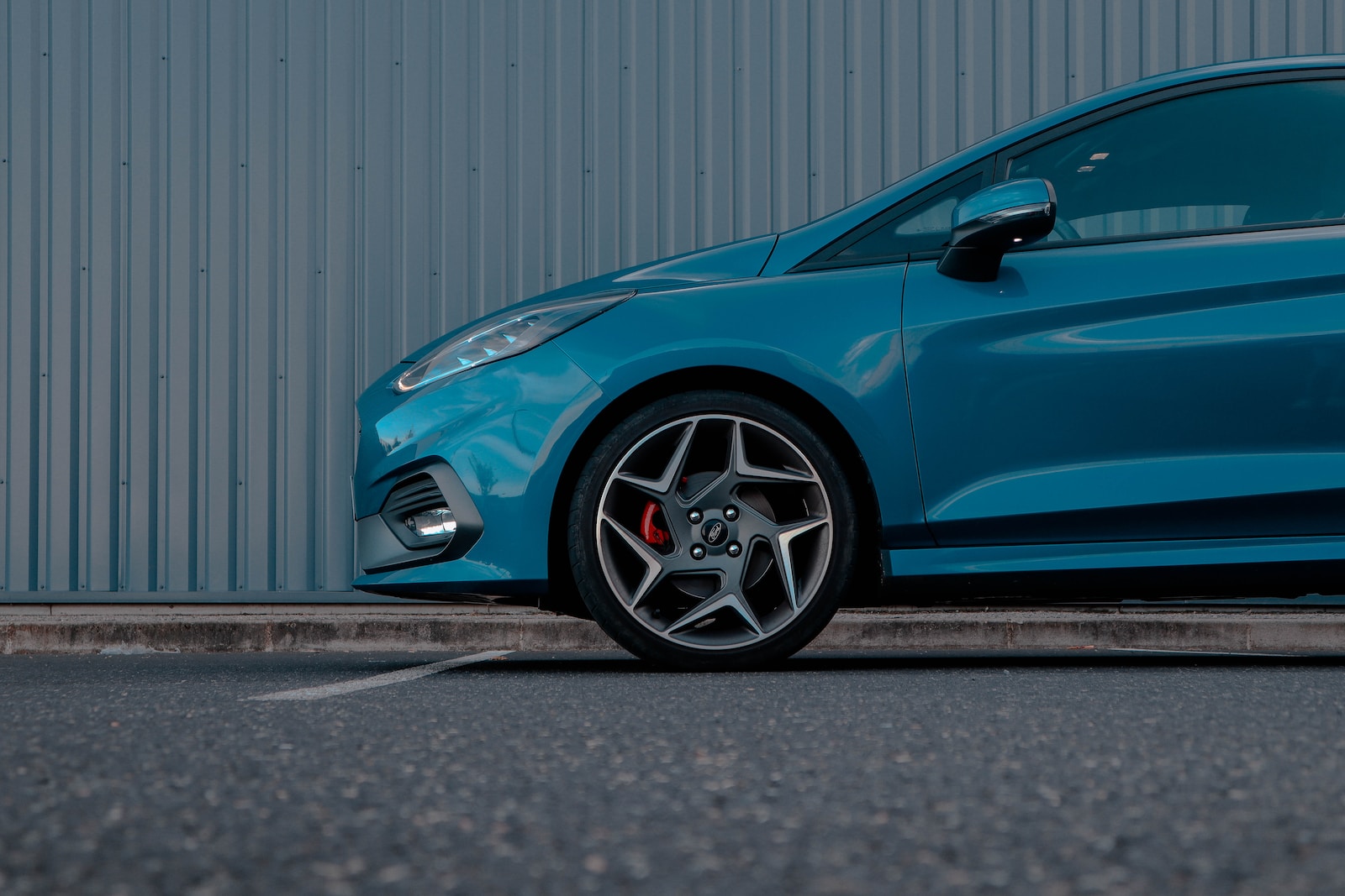 a blue car parked in front of a building