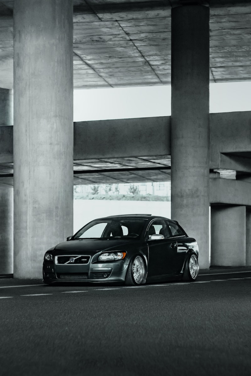 a black car is parked in a parking garage