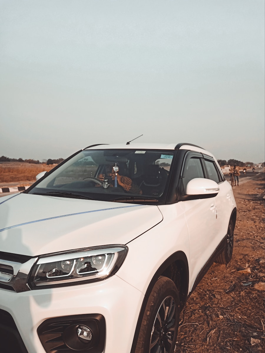 a white car parked on a dirt road