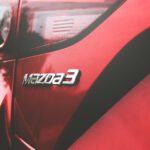 closeup photography of red Mazda 3 vehicle