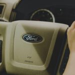 person holding Ford steering wheel