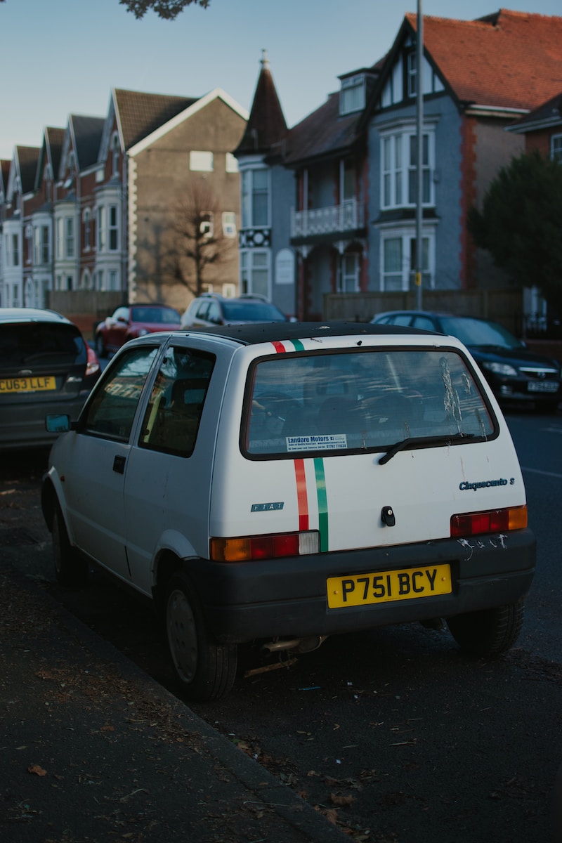 a small white car parked on the side of the road