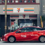 red sedan parked in front of store