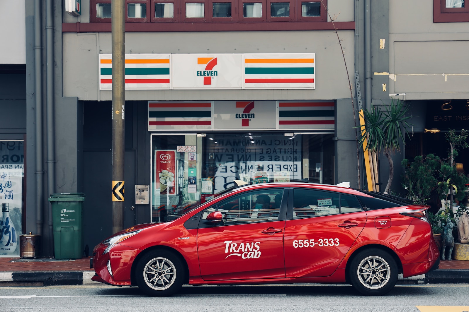 red sedan parked in front of store